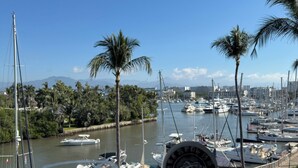 A glass of beverage on a coaster, overlooking a marina with boats and palm trees. - Paradise to live in! (Nuevo Vallarta)