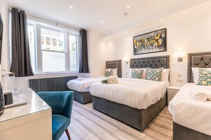 A hotel room with two beds, a desk, a chair, and a large window. - The Gate Hotel (London)