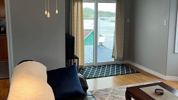 Een woonkamer met een leren bank, een houten salontafel en een plafondventilator.