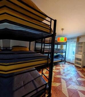 Bunk beds in a room with a patterned floor and a hanging light fixture. - Hostel Élisée Perpignan (Perpignan)