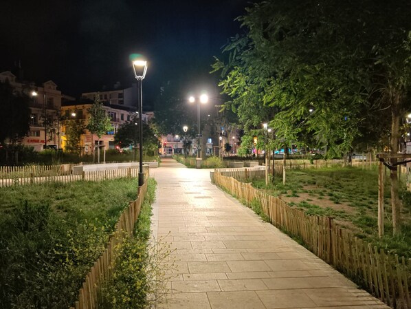 A nighttime pathway with street lamps, bordered by wooden fences and greenery. - Hostel Élisée Perpignan (Perpignan)