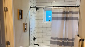 A bathroom with a toilet, bathtub, and shower curtain.