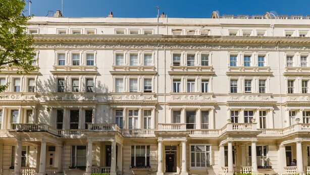 A multi-story building with a symmetrical facade, large windows, and a central entrance with steps. - The Hyde Hotel (London)