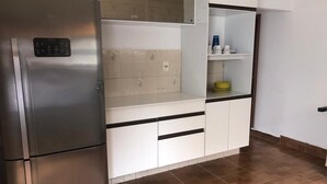 A kitchen with a stainless steel refrigerator, white cabinets, and a tiled backsplash. - Seaside House (Parque Balneario Comodoro Mongaguá)