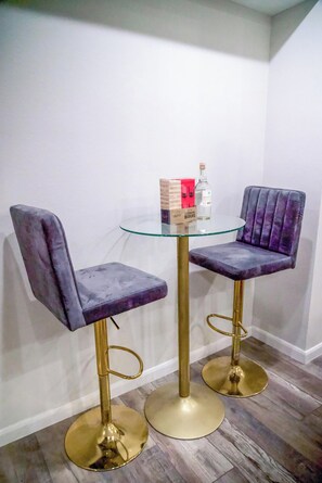 Two purple upholstered chairs with gold legs and a glass table in a corner. -  Charming 3-bedroom house with WiFi and AC in Houston - Unit #1 (Houston)