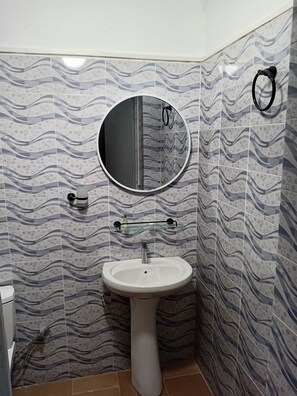 A bathroom with a white sink, a round mirror, and a towel rack. - Melia Beach (Mbour)
