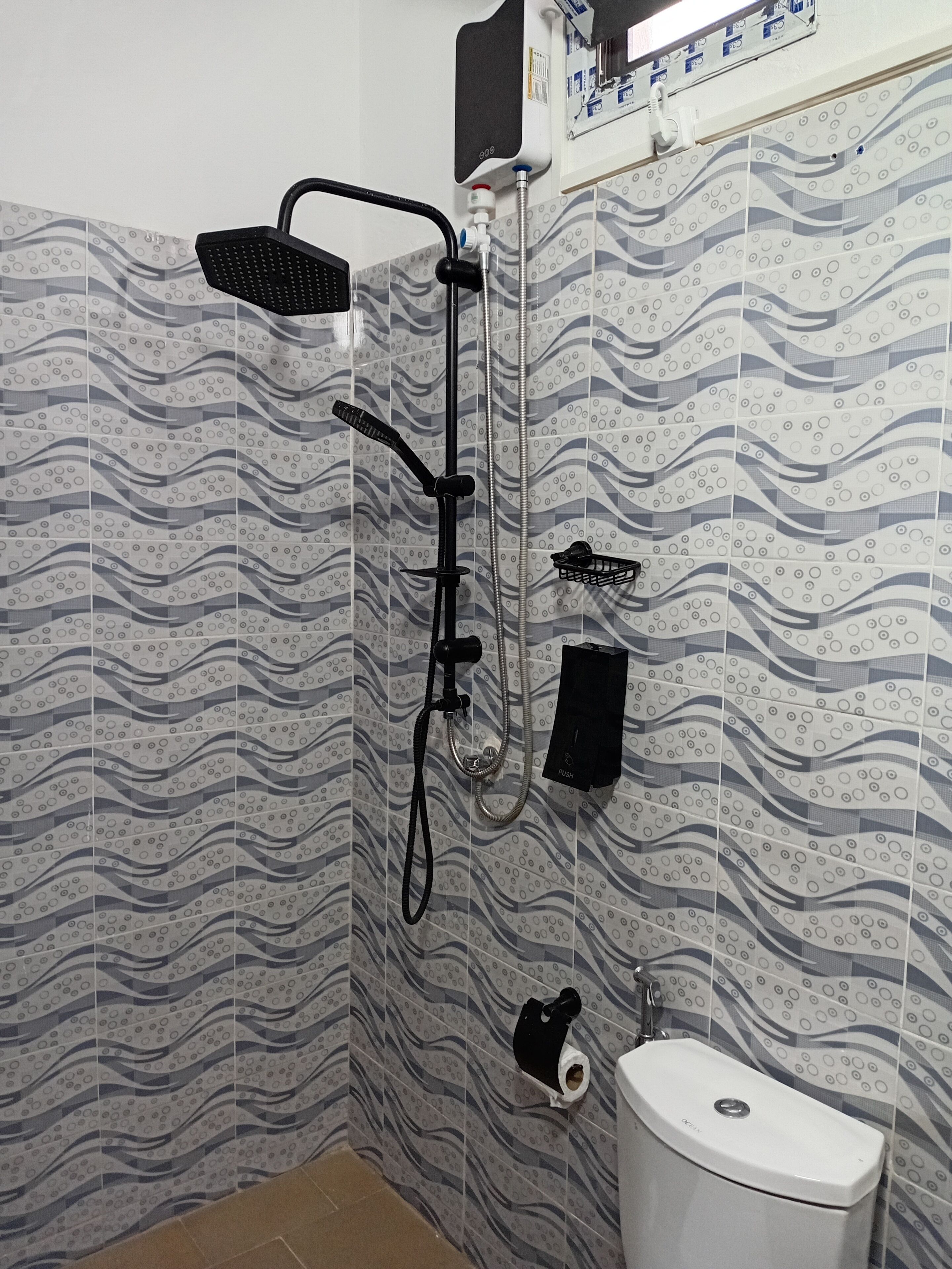 A bathroom with a shower, toilet, and a towel rack.