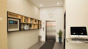 A modern reception area with a reception desk, computer, and an elevator. - Ripple Hotel (Shanghai Xinqiao Town) (Shanghai)