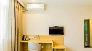A hotel room with a wooden desk, a chair, a bed, a TV mounted on the wall, and an air conditioning unit. - Ripple Hotel (Shanghai Xinqiao Town) (Shanghai)