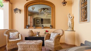 A cozy room with wicker furniture, a mirror, and decorative items. - Domus Aenaria - Spacious Villa - Prime location close to beaches and shops (Ischia)