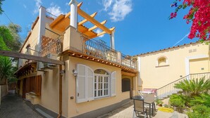 A two-story building with a balcony, a staircase, and a small outdoor seating area. - Domus Aenaria - Spacious Villa - Prime location close to beaches and shops (Ischia)