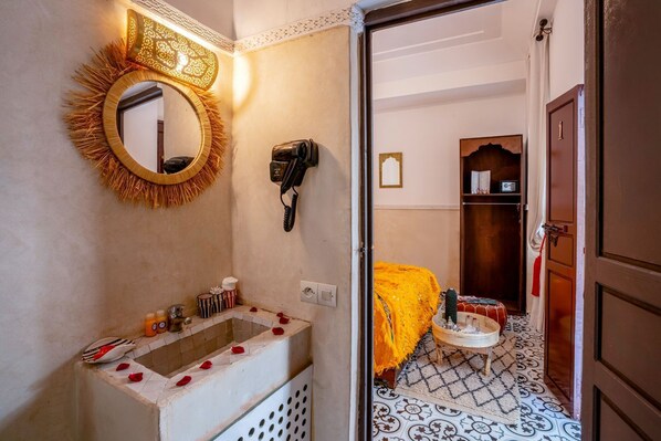 A bathroom with a sink, mirror, and a telephone. - Riad Nowara & Spa (Marrakech)