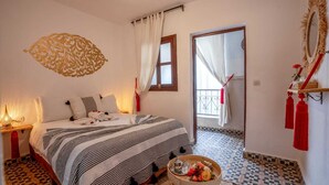 Quarto com cama, mesa de cabeceira e uma pequena mesa com bandeja.