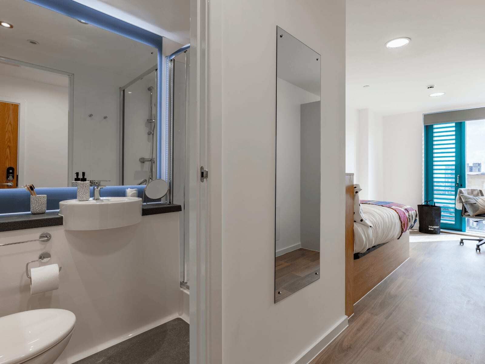 Et moderne badeværelse med vask, toilet og bruser.