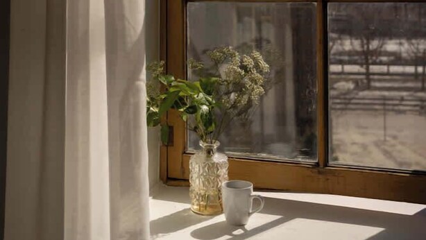 A window with a view of a snowy landscape, a white vase with flowers, and a white mug on a windowsill. - Maison Rasco • One-Bedroom Apartment • Old Montreal • Central • Self Check-In Access • Full Kitchen • Pet Friendly • Wi-Fi • AC (Montreal)