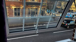 Vista a través de una ventana de un edificio, con un letrero que dice "CAPE OF COWLEY ROAD".