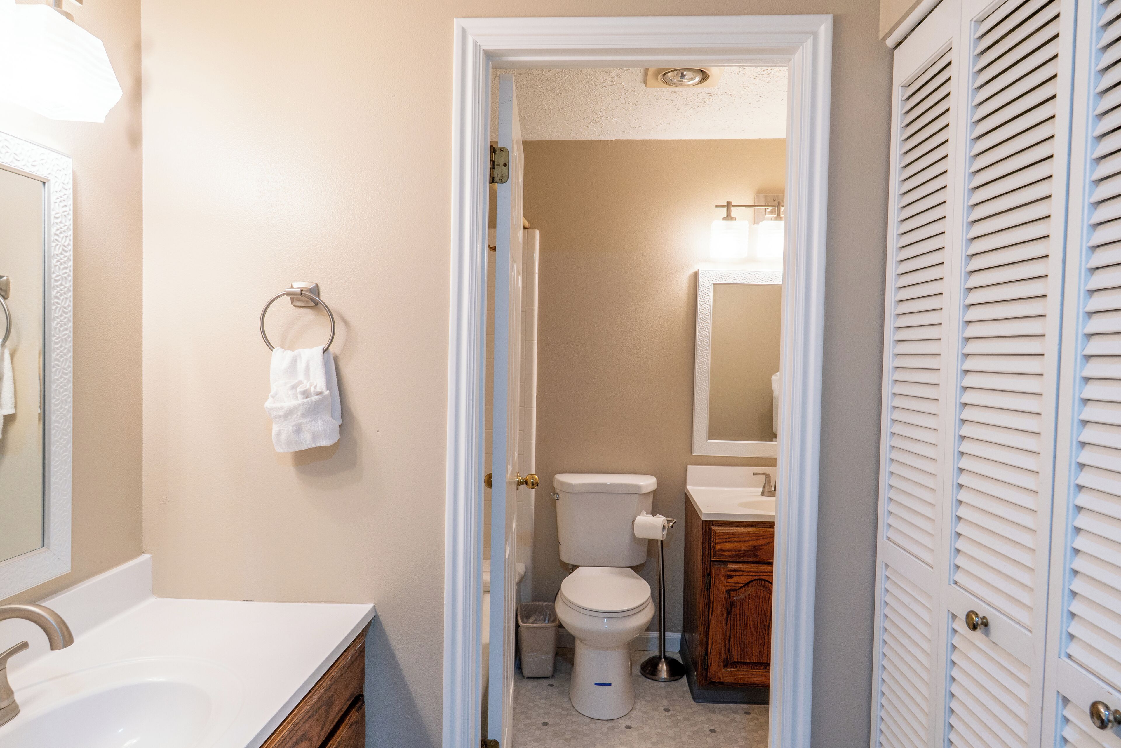 A bathroom with a toilet, sink, and mirror.