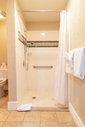 Deluxe tweepersoonskamer | Badkamer | Een bad/douchecombinatie, een haardroger, handdoeken, shampoo