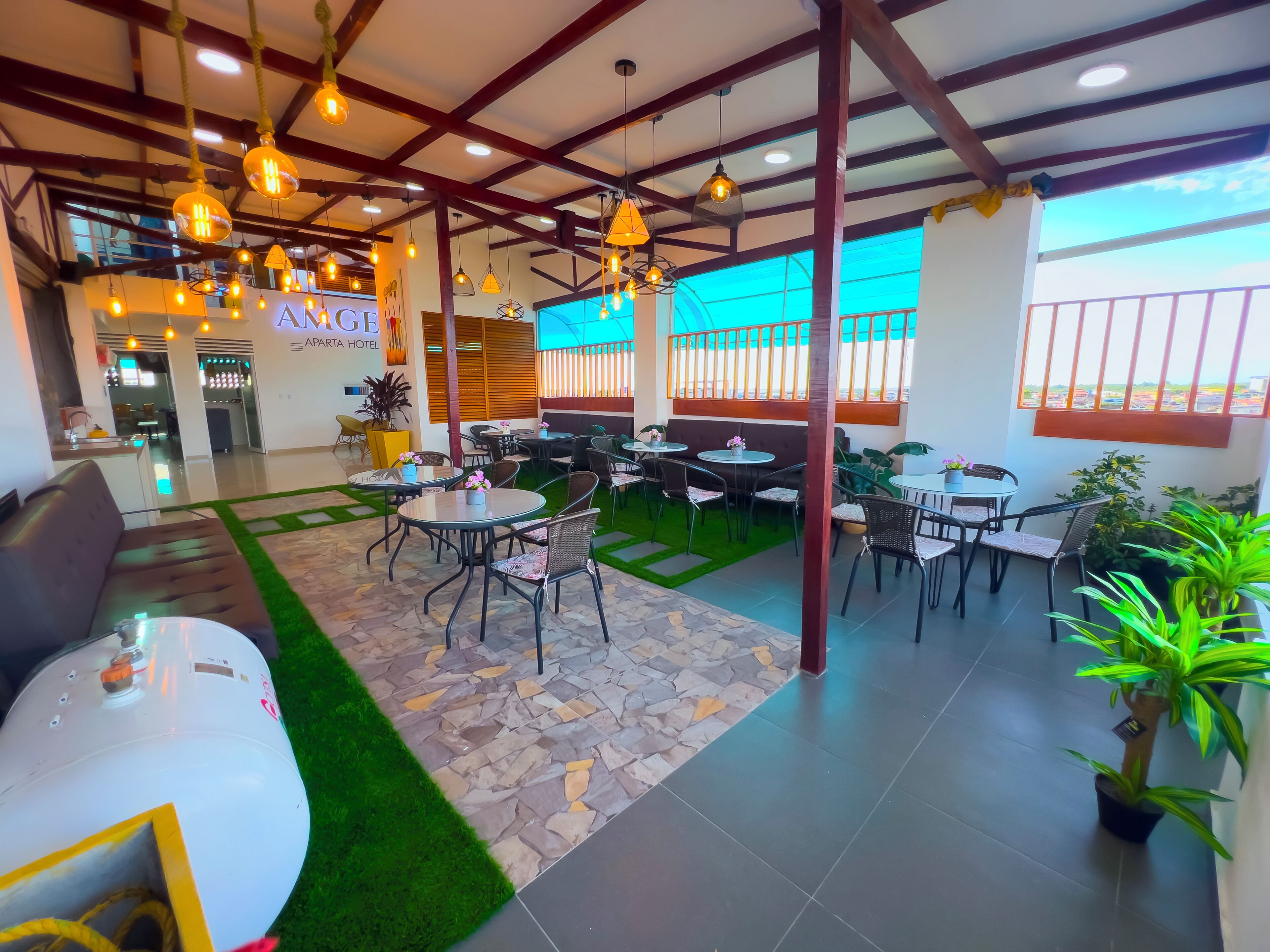 A hotel lobby with multiple seating areas, a reception desk, and a view of the outside.