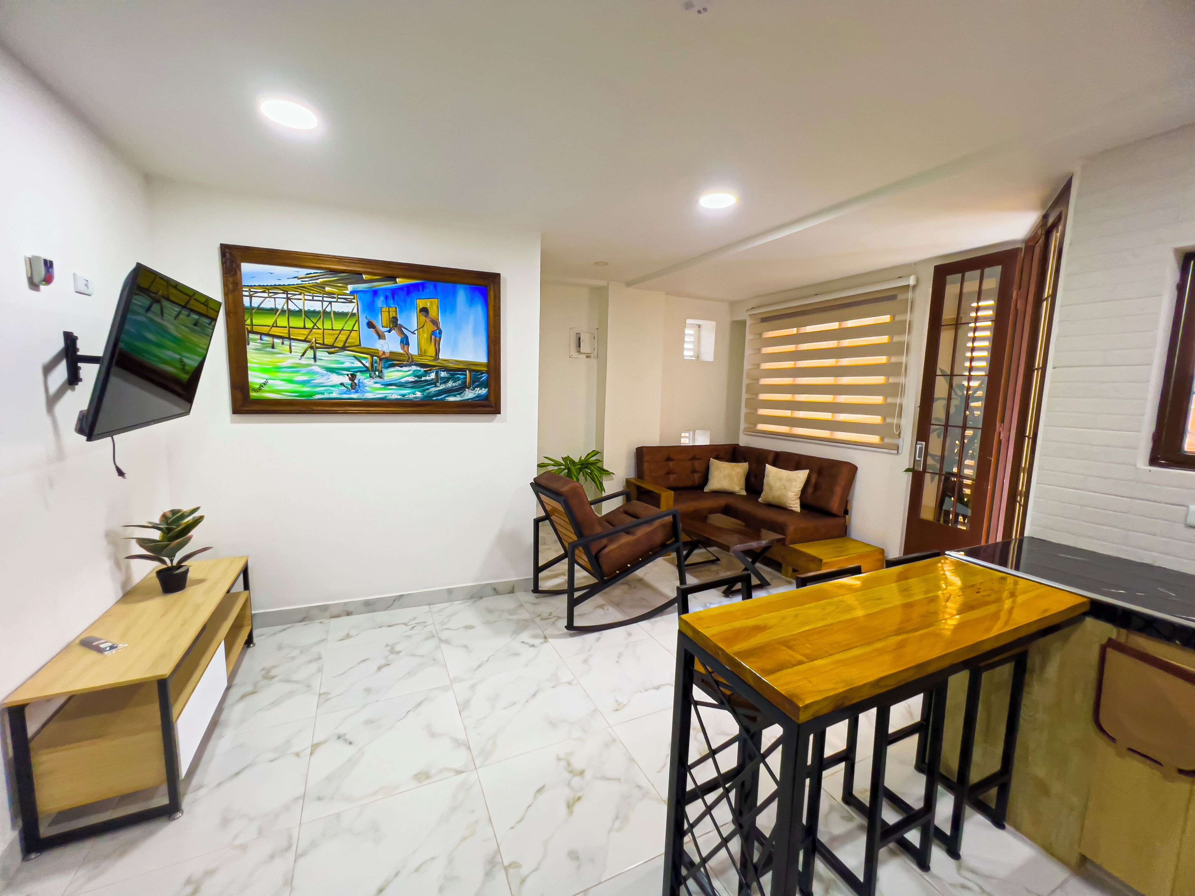 Una sala de estar moderna con un sofá, una mesa de centro y un televisor montado en la pared.