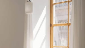 Una habitación con un ventanal grande, una mesa y sillas.