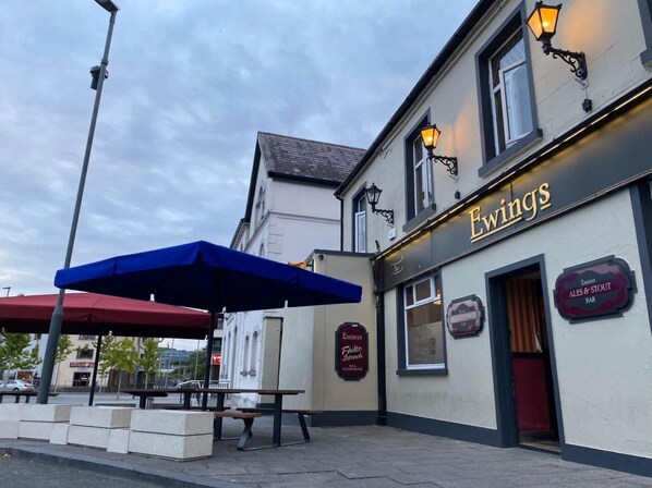 A building with a sign reading "Ewing's" and "Ales & Stout Bar" indicating a pub or restaurant. - Ewings Bar & Self-Catering Accommodation (Carlow)