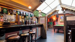 A bar area with multiple stools, a pool table, and a variety of beer taps. - Ewings Bar & Self-Catering Accommodation (Carlow)