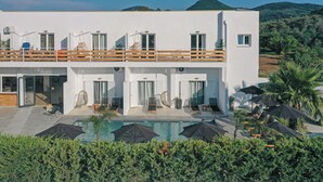 Un edificio moderno de dos pisos con piscina y asientos exteriores.