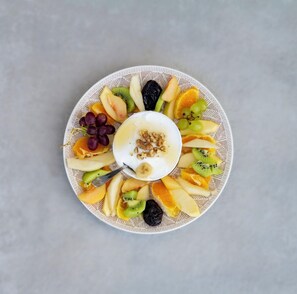 Ein Teller mit verschiedenen Früchten und einem Klecks Joghurt mit Walnüssen.