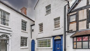 A traditional white building with a blue door, multiple windows, and a visible chimney. - Spacious home, sleeps 9 - walker & cyclist retreat -Pass the Keys (Shropshire)