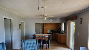 Un salón espacioso con comedor, cocina y un amplio ventanal que proporciona luz natural.