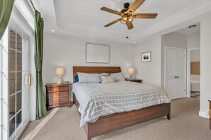 A bedroom with a bed, nightstands, a ceiling fan, and a large window with curtains. - Mountain Views + Walk to Overlook Barn, Slopes, Fred's & White Wolf! (Banner Elk)