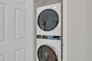A white wall-mounted washer and dryer unit with a glass door, allowing visibility into the interior. - Mountain Views + Walk to Overlook Barn, Slopes, Fred's & White Wolf! (Banner Elk)