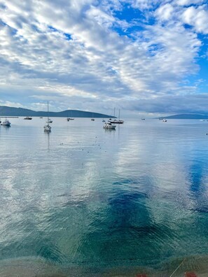 A calm body of water with several boats anchored, a clear sky, and distant landforms. - Surfer Caravan Gastro Pub and Suites (Bodrum)