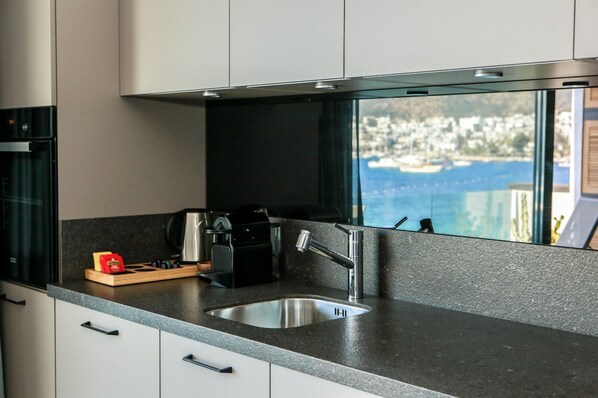 A modern kitchen with a stainless steel sink, a coffee maker, and a knife block. - Surfer Caravan Gastro Pub and Suites (Bodrum)