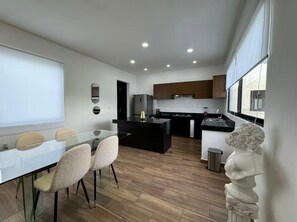 Enjoy cooking in this well-equipped kitchen with a sleek island, stainless steel range, and ample natural light.