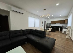 Relax in a stylish living space with a sofa, dining table, and fully equipped kitchen.