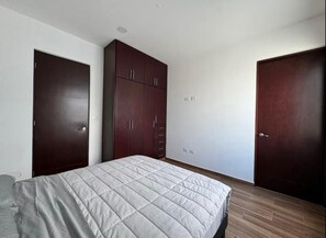 Cozy retreat with a comfortable bed and ample storage in a simple, functional space.