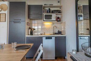 A compact kitchen with grey cabinets, a built-in microwave, and a dishwasher. - 200m from ski slopes, 3rd floor, swimming pool, balcony, tv, ski locker, 24m², Les Orres (Les Orres)