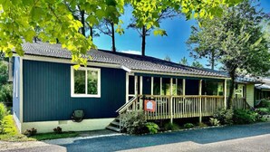 A single-story mobile home with a porch, a small front yard, and a mailbox.