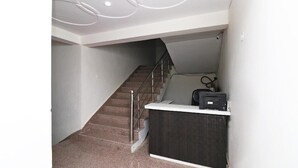 A staircase with a handrail, a dark counter, and a wall-mounted device. - Vrinda Residency (Vrindavan)