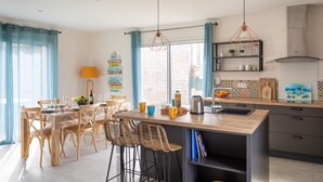 A modern kitchen with a wooden island, bar stools, and pendant lighting. - Côte et mer - Proche plage, parking privé (Erquy)