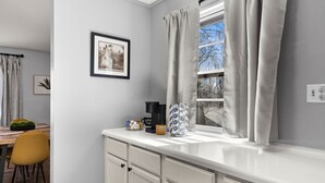 A kitchen with a white countertop, a coffee maker, and a decorative item. - Cozy Home in Oak Ridge w/ 3BR (Oak Ridge)