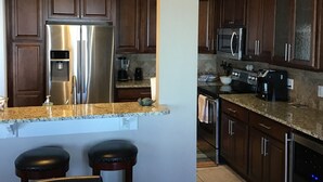 A modern kitchen with dark wooden cabinets, stainless steel appliances, and a granite countertop. - Lakefront Condo 2br/2ba 208 indoor pool, beach/balcony. Rent 3/4th free-ask (Geneva)