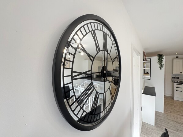 Contemporary space with a large wall-mounted clock and dining area.
