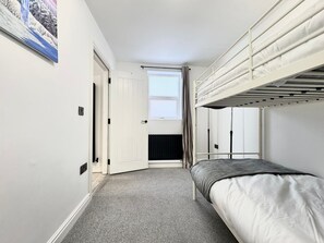 Cozy retreat with a bunk bed arrangement and a door leading to another room.