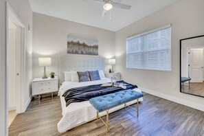 A bedroom with a bed, bedside tables, a bench, a ceiling fan, a painting, and a window with blinds. - Trendy One Bedroom Getaway Steps from Biscayne (Miami)
