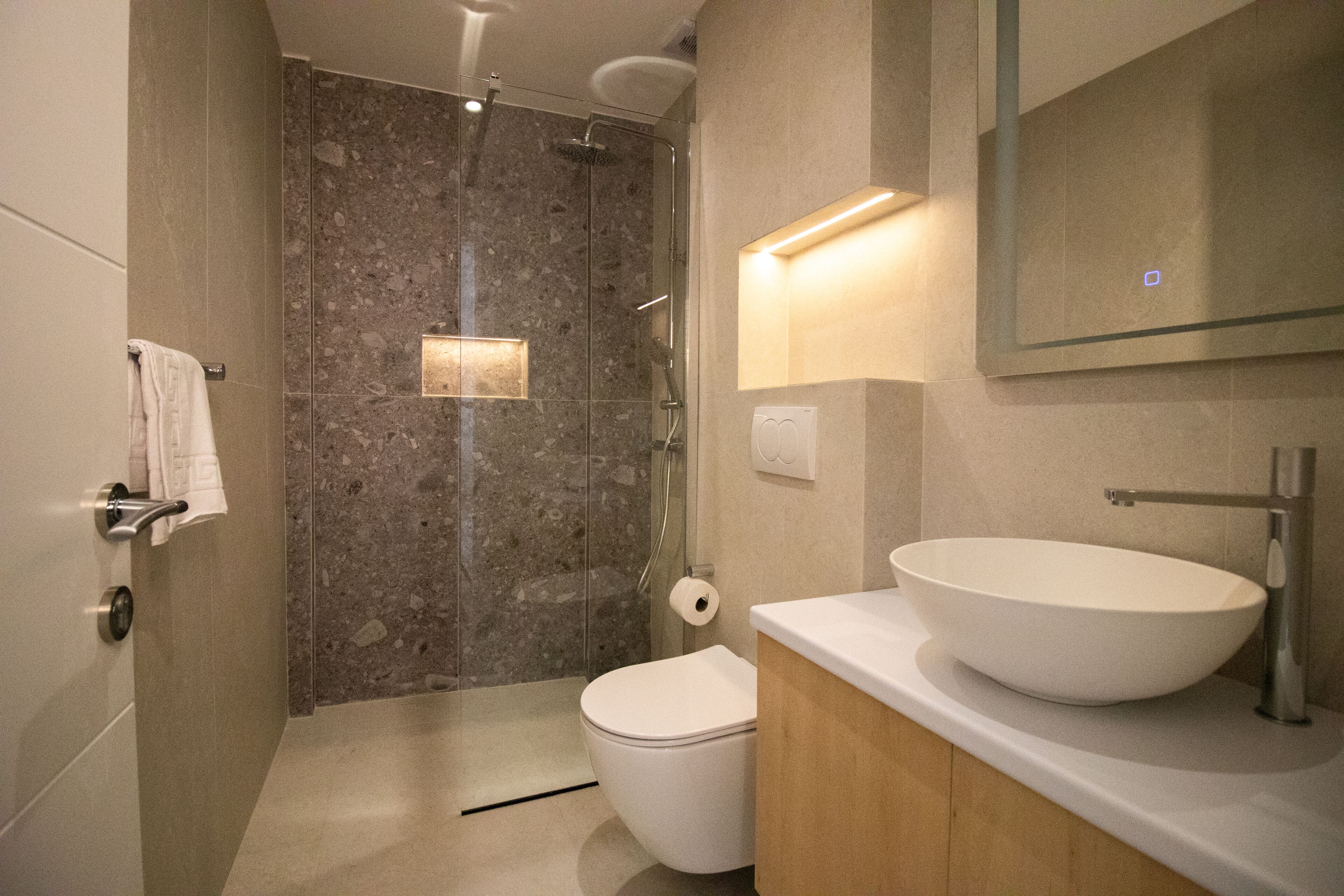 A modern bathroom with a large sink, a toilet, and a shower area.