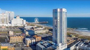 Ein Hochhaus-Hotel mit Blick auf das Meer und einem Pier im Hintergrund.