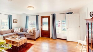 Una sala de estar con sofá, mesa de centro y cortinas.